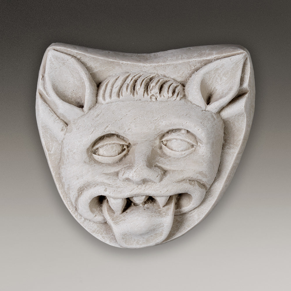 Reproduction of a Medieval carving of a demon with ears and fangs sticking its tongue out